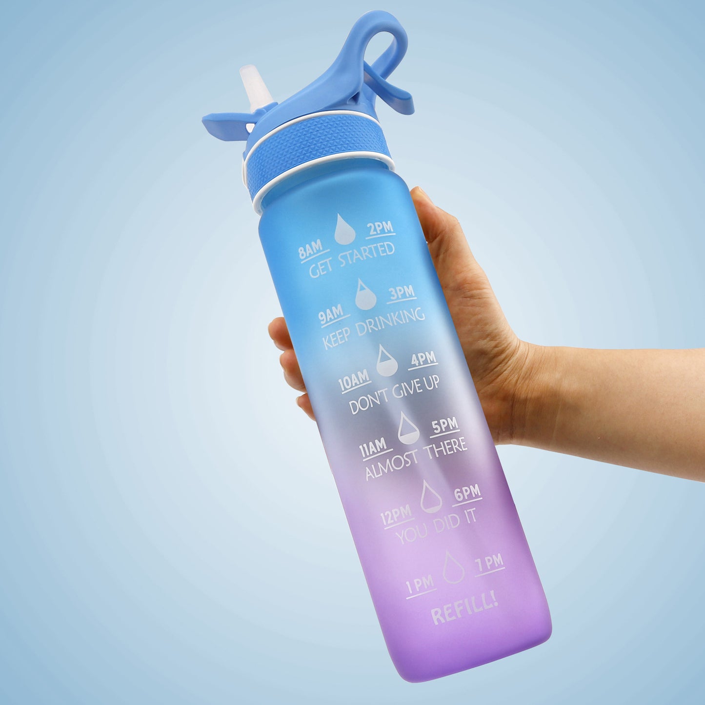 Hand håller i en blå en lila Vattenflaska med sprej 1000 ml