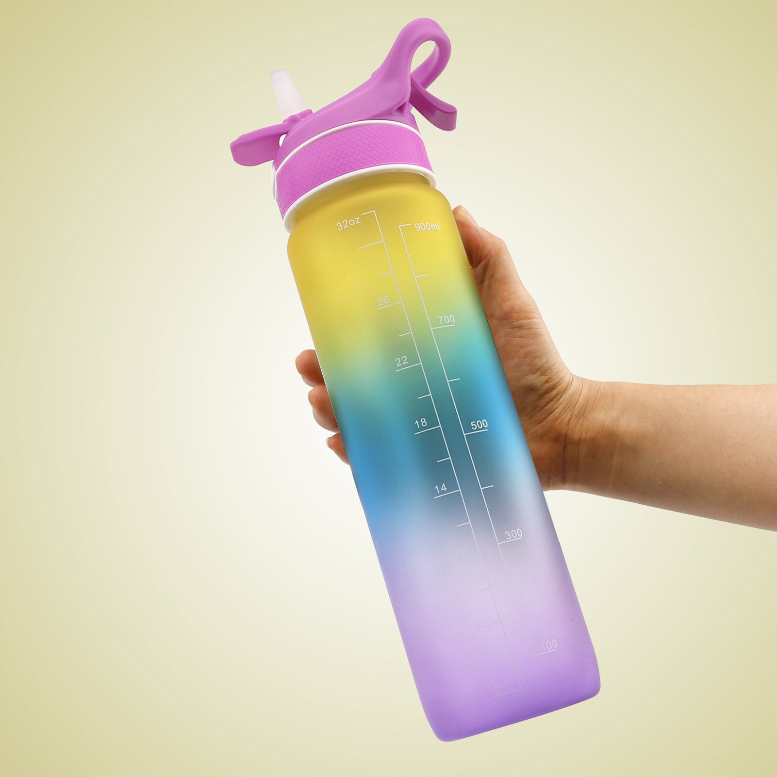 Hand håller i en rosa, gul, blå och lila  Vattenflaska med sprej 1000 ml