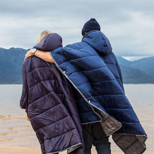 Två personer bär en Varm campingponcho